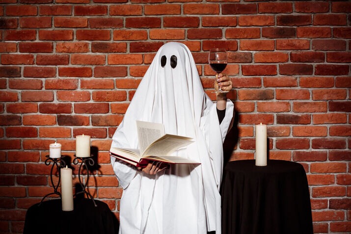 Ghost costume holding an open book for spooky storytelling